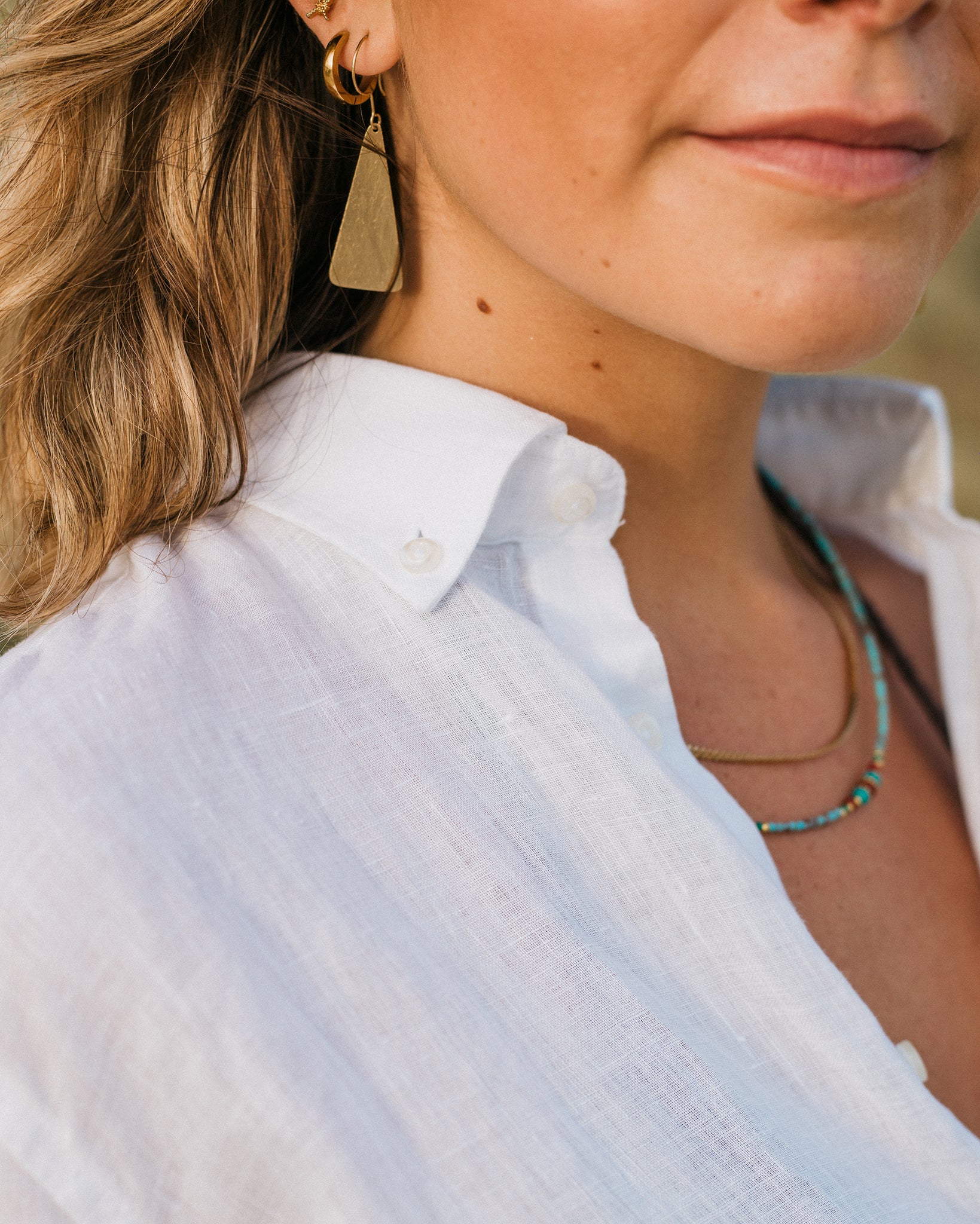 Detail shot of a girl wearing a white linen button down shirt