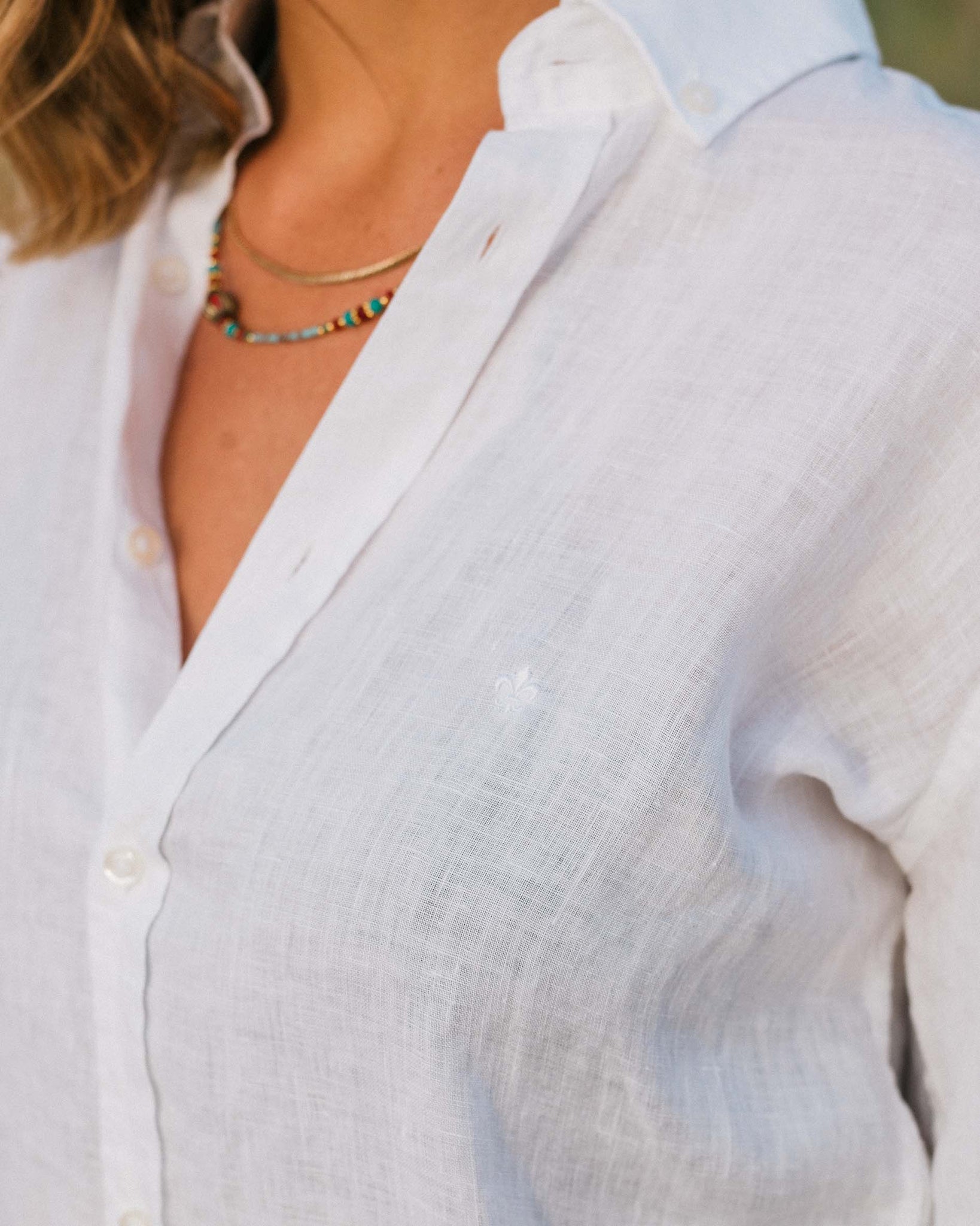 Detail shot of a girl  wearing a white linen button down shirt