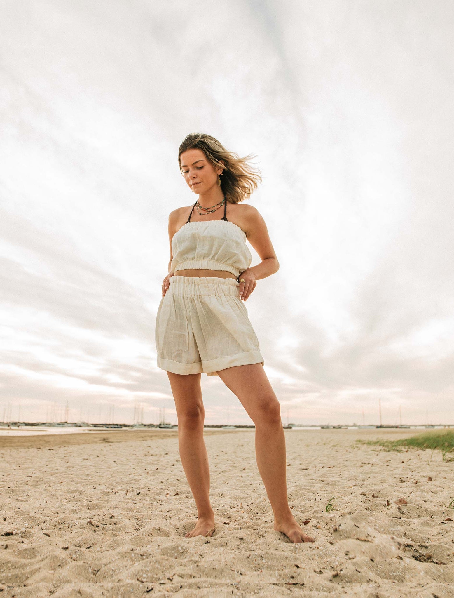 Girl standing on the beach in natural organic cotton shorts